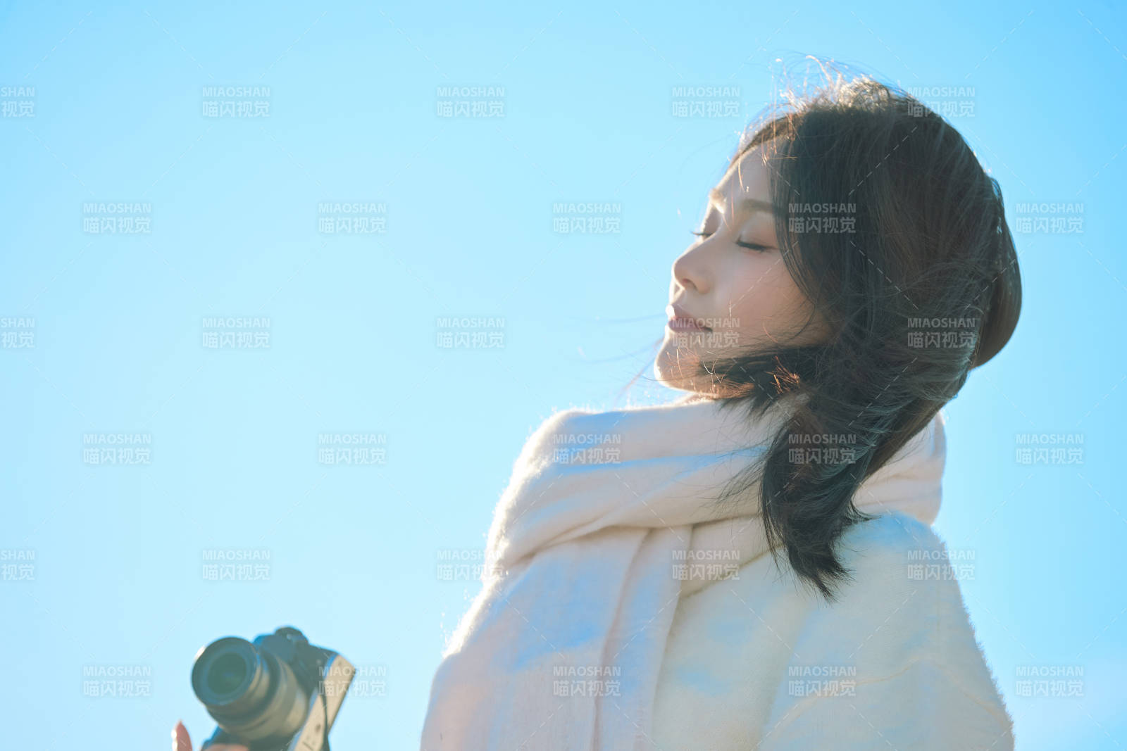 拿着相机的美女摄影师在深秋的户外拍摄