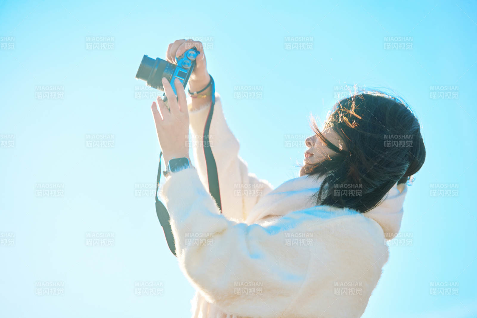 拿着相机的美女摄影师在深秋的户外拍摄