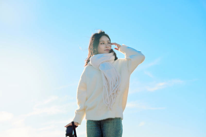 拿着相机的美女摄影师在深秋的户外拍摄