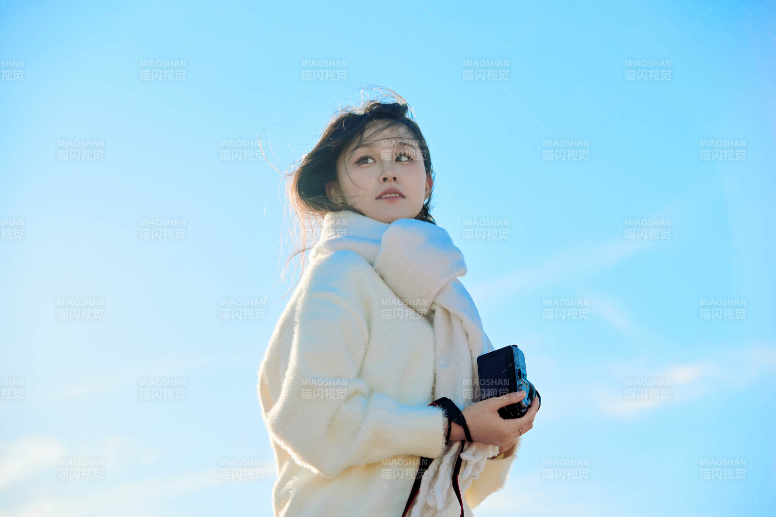 拿着相机的美女摄影师在深秋的户外拍摄