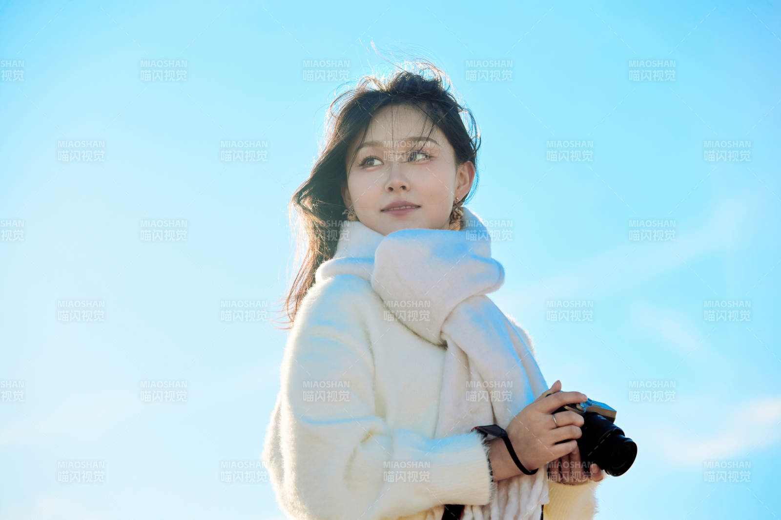 拿着相机的美女摄影师在深秋的户外拍摄