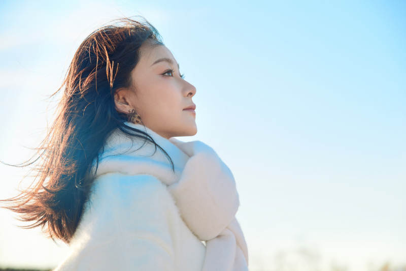 拿着相机的美女摄影师在深秋的户外拍摄