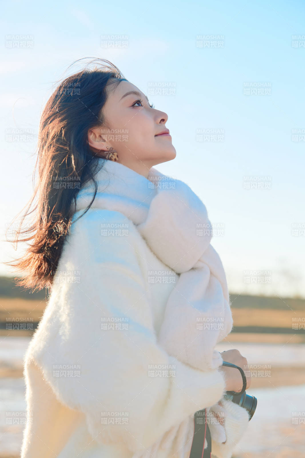 拿着相机的美女摄影师在深秋的户外拍摄