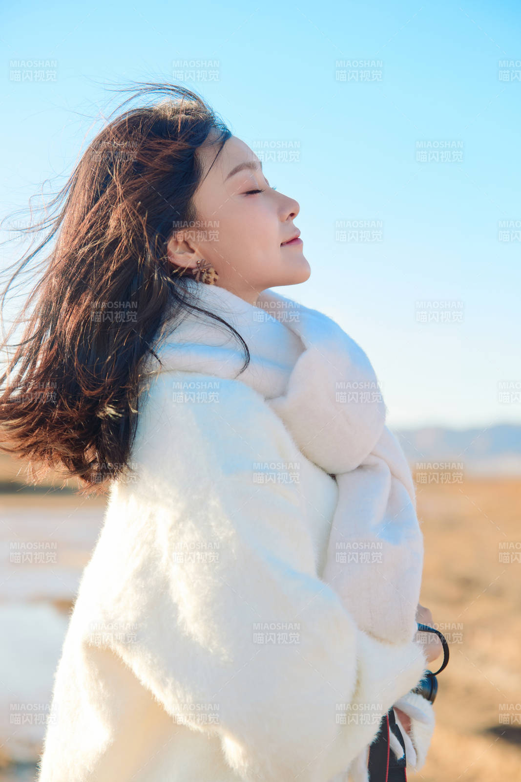 拿着相机的美女摄影师在深秋的户外拍摄