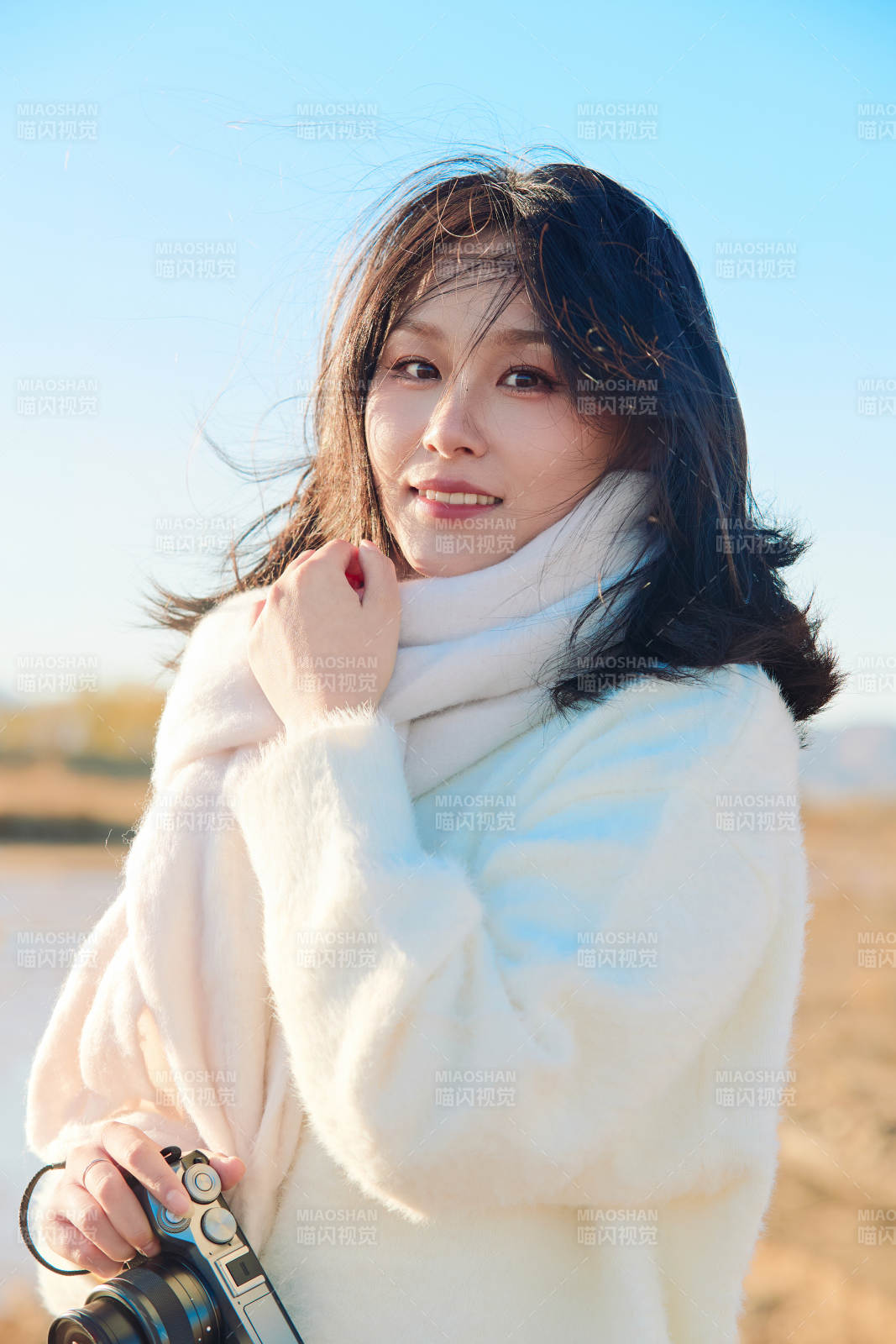 拿着相机的美女摄影师在深秋的户外拍摄