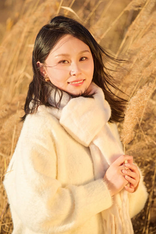 秋天午后在金灿灿的芦苇荡里的亚洲美女