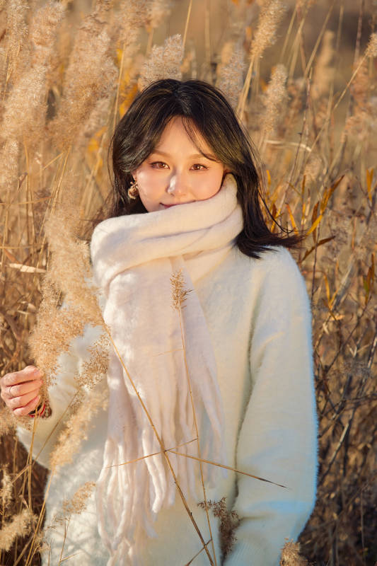 秋天午后在金灿灿的芦苇荡里的亚洲美女