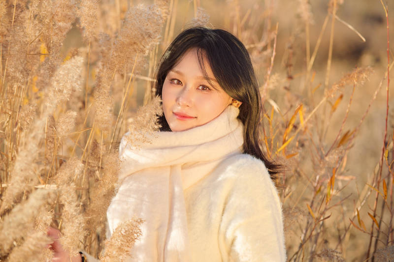 秋天午后在金灿灿的芦苇荡里的亚洲美女