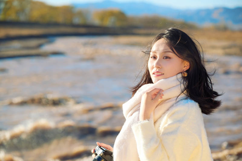 深秋户外手持相机的亚洲女性摄影师