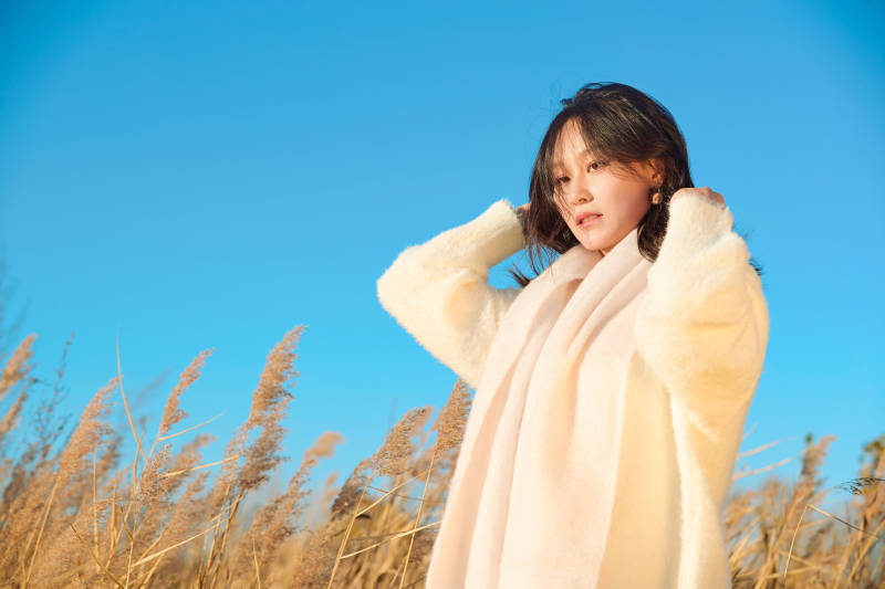 秋天晴朗的午后在芦苇荡里起舞的美女