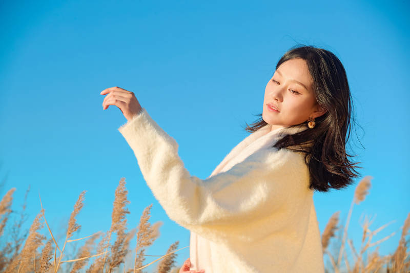 秋天晴朗的午后在芦苇荡里起舞的美女