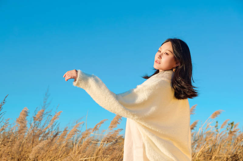 秋天晴朗的午后在芦苇荡里起舞的美女