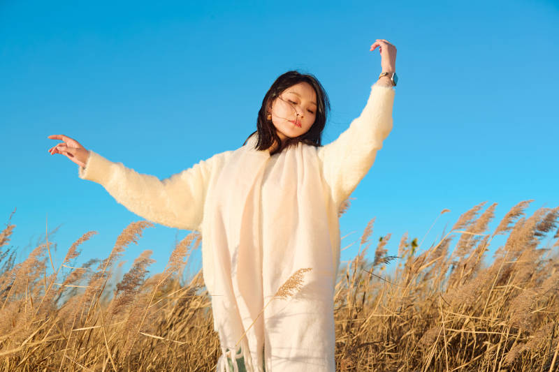 秋天晴朗的午后在芦苇荡里起舞的美女