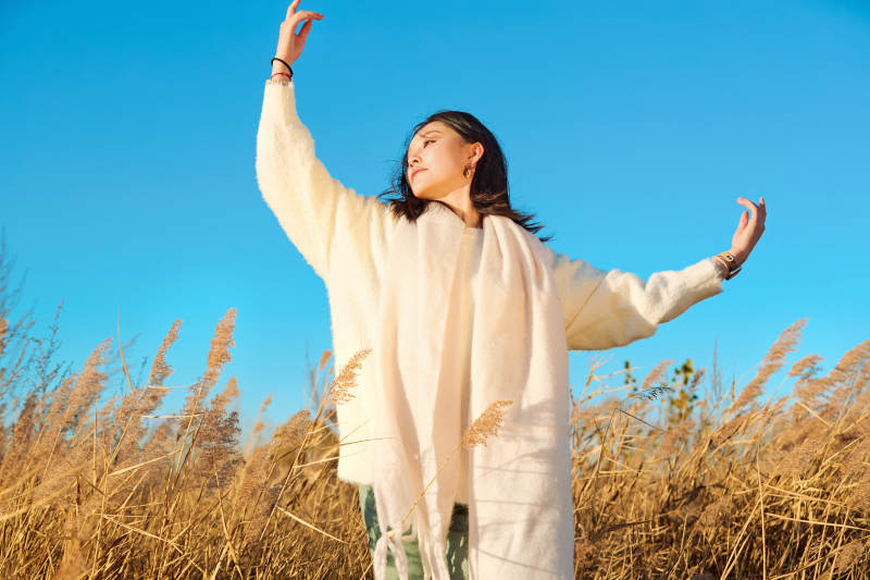 秋天晴朗的午后在芦苇荡里起舞的美女