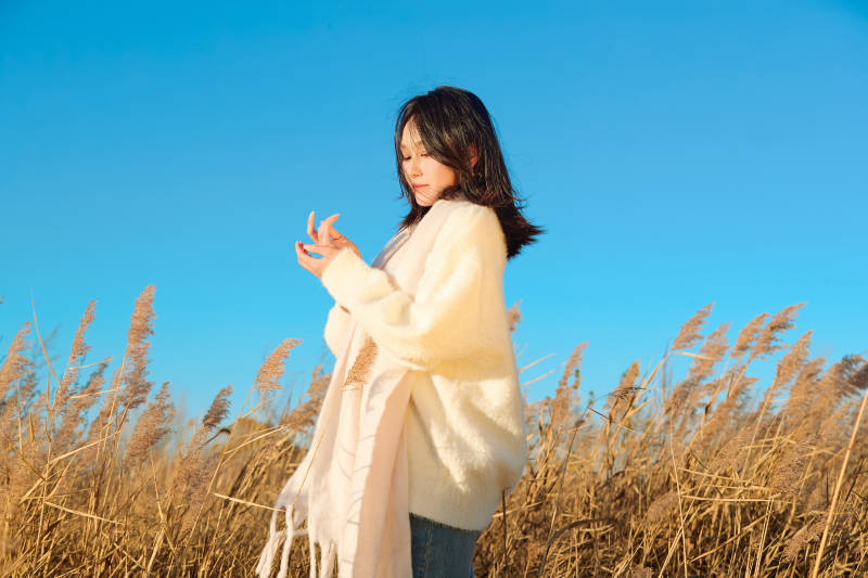 秋天晴朗的午后在芦苇荡里起舞的美女