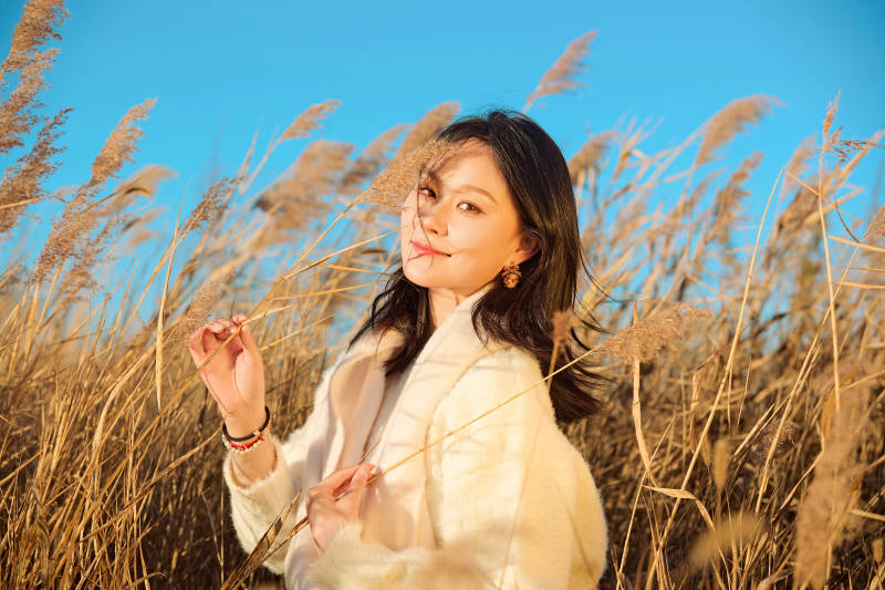 秋天晴朗的午后在芦苇荡里起舞的美女