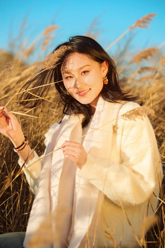 秋天晴朗的午后在芦苇荡里起舞的美女