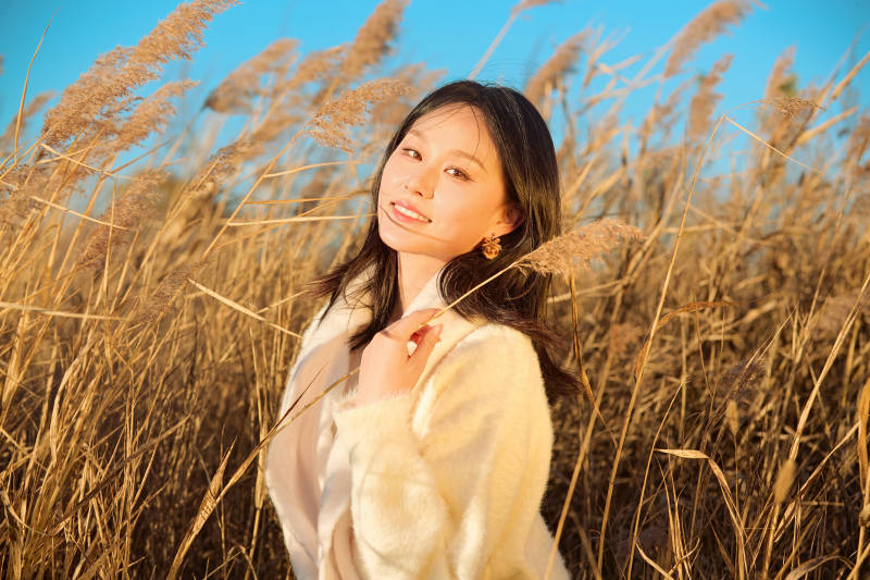 秋天晴朗的午后在芦苇荡里起舞的美女