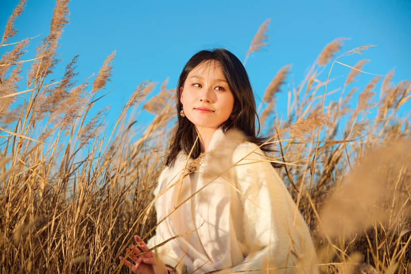 秋天晴朗的午后在芦苇荡里起舞的美女