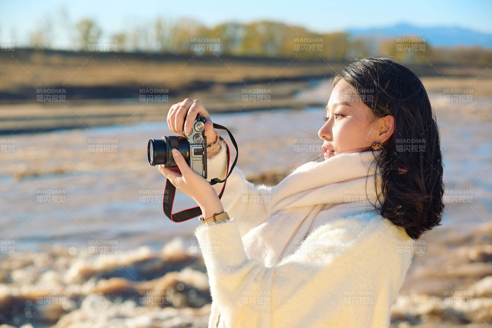 深秋户外手持相机的亚洲女性摄影师