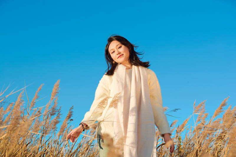 秋天晴朗的午后在芦苇荡里起舞的美女