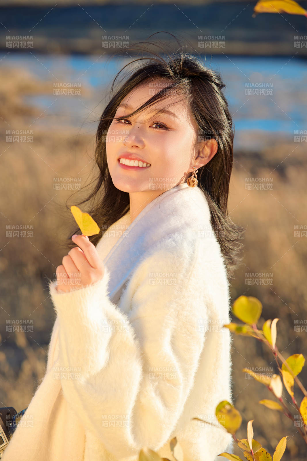 秋天晴朗的午后在芦苇荡里拍照的女性摄影师