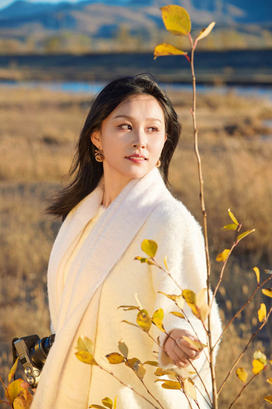 秋天晴朗的午后在芦苇荡里拍照的女性摄影师