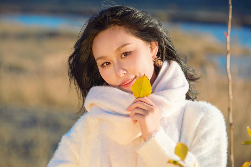 秋天午后在金灿灿的芦苇荡里的亚洲美女