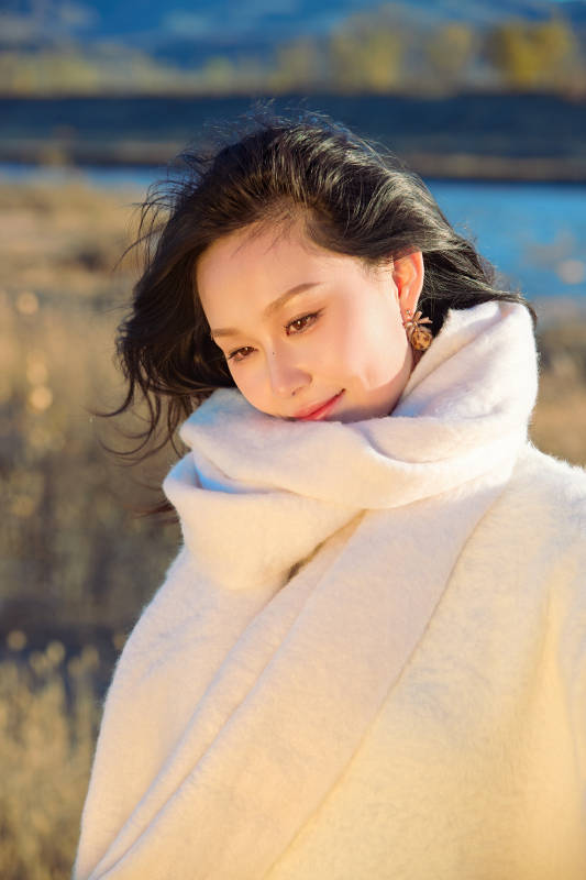 秋天午后在金灿灿的芦苇荡里的亚洲美女