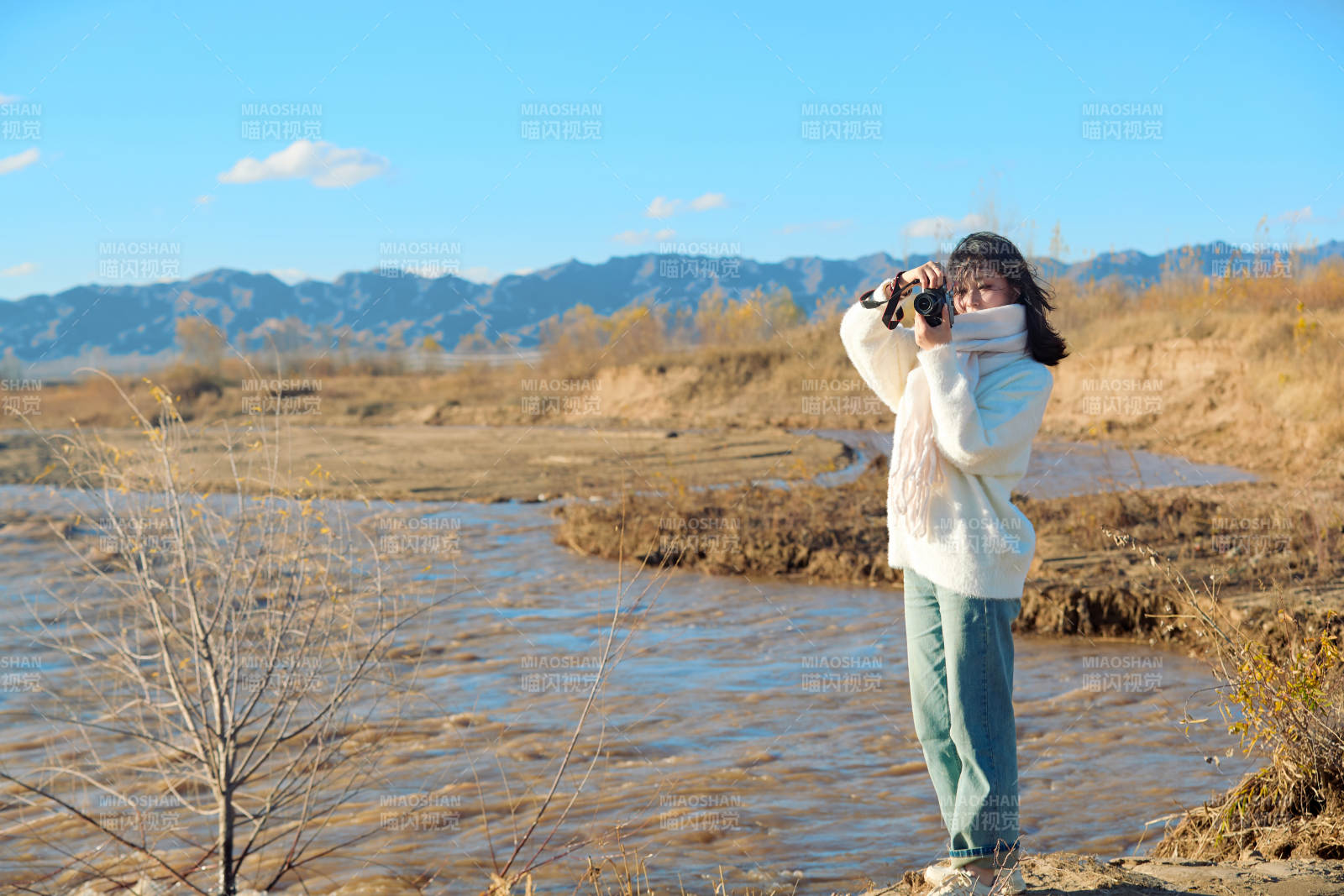 深秋户外手持相机的亚洲女性摄影师