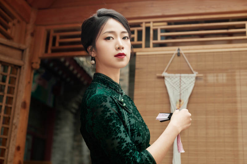 在中式庭院里身穿復古旗袍的亞洲女性