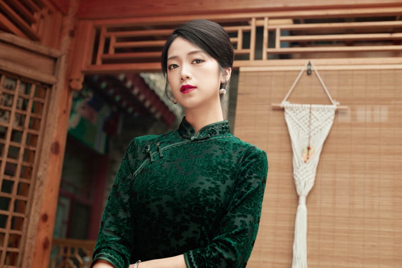 在中式庭院里身穿复古旗袍的亚洲女性