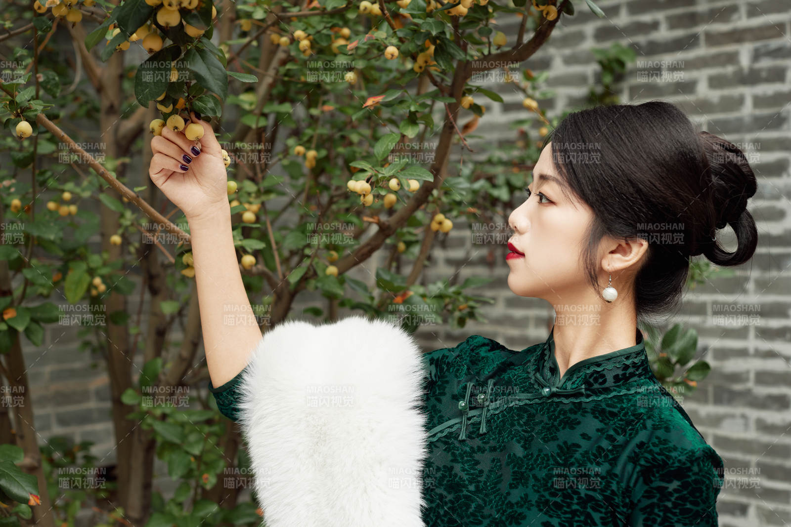 身穿旗袍在庭院散步的年轻美女