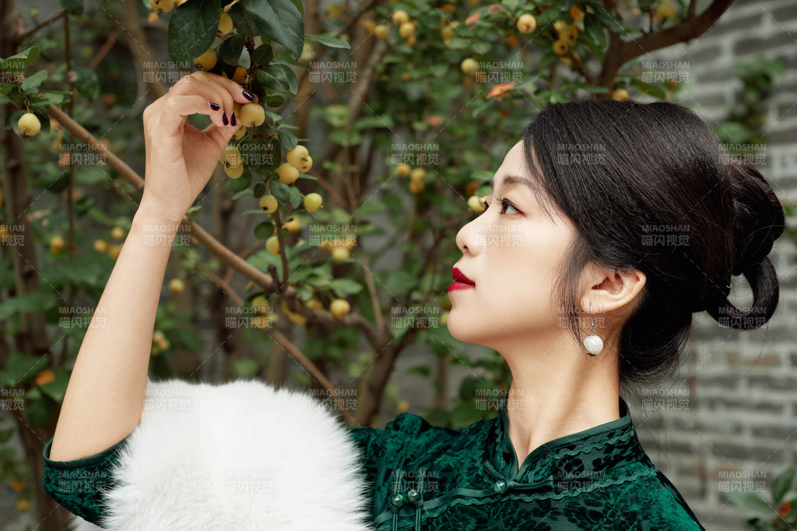 身穿旗袍在庭院散步的年轻美女