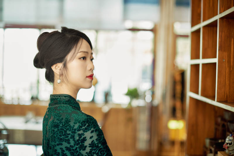 在中式茶社内穿着复古旗袍的中国女性