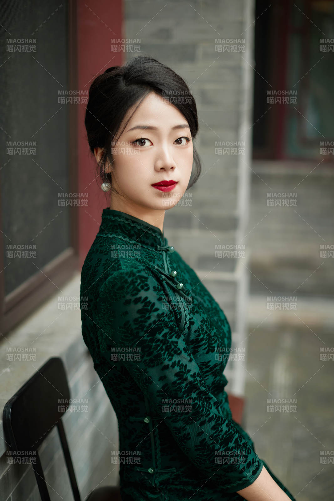 坐在中式庭院里身穿复古旗袍的亚洲女性