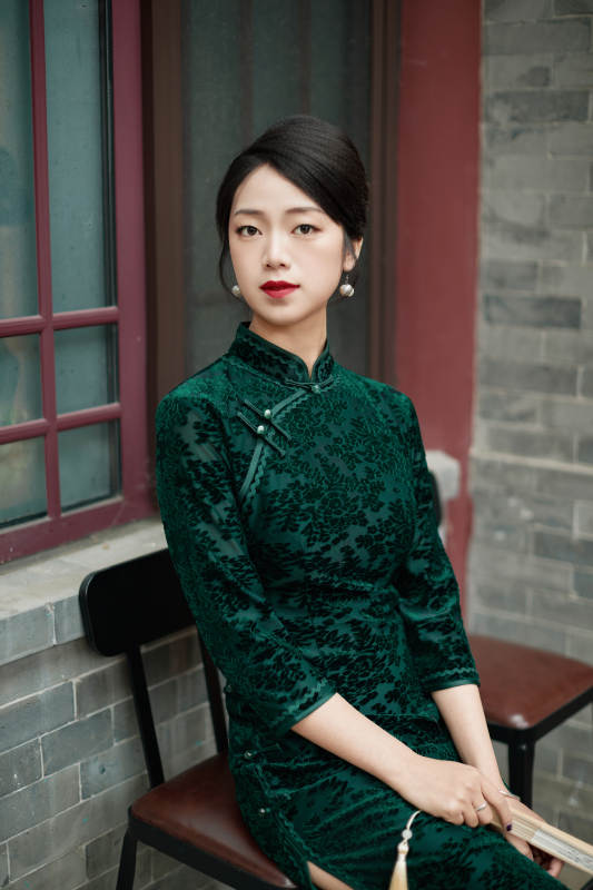 坐在中式庭院里身穿复古旗袍的亚洲女性