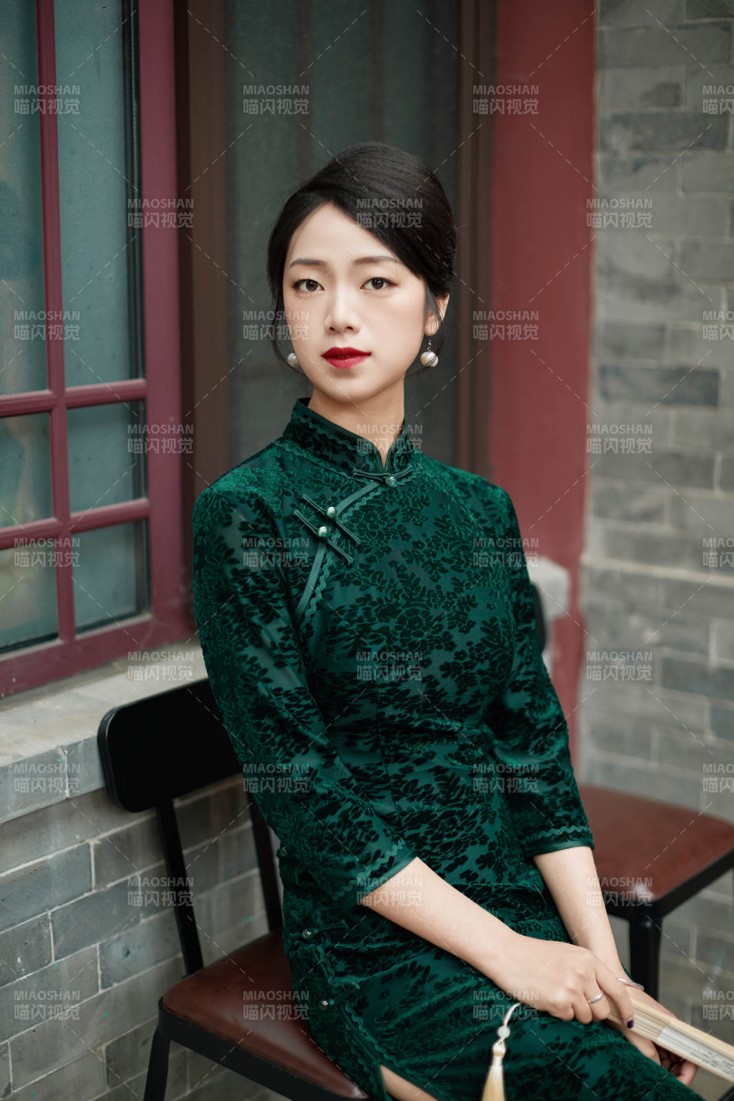 坐在中式庭院里身穿复古旗袍的亚洲女性