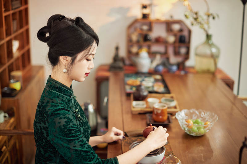 穿着旗袍展示茶道文化的亚洲美女