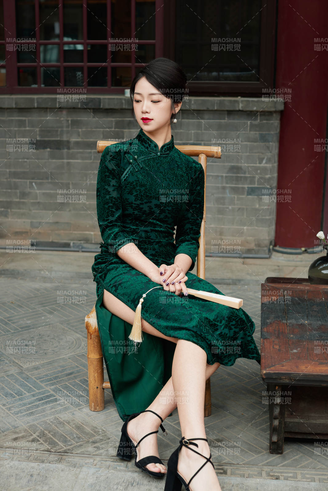 坐在中式庭院里身穿复古旗袍的亚洲女性