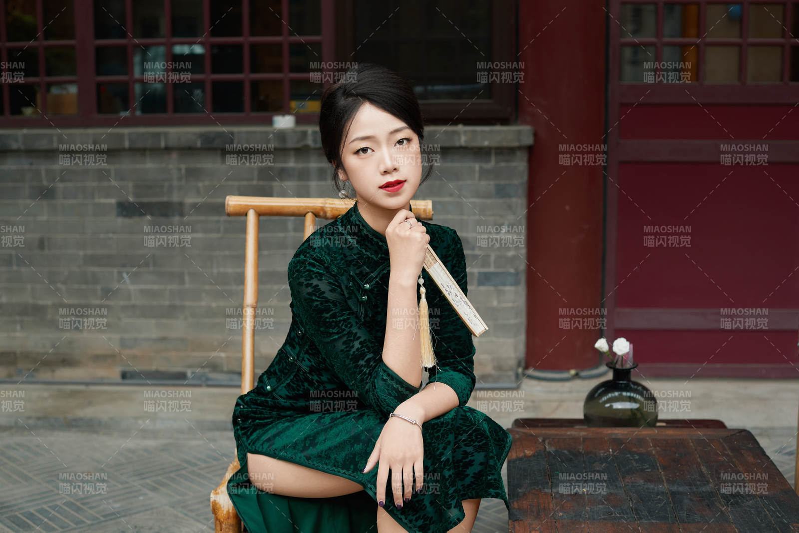 坐在中式庭院里身穿复古旗袍的亚洲女性