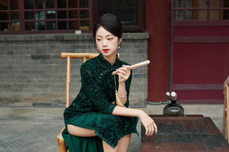 坐在中式庭院里身穿复古旗袍的亚洲女性