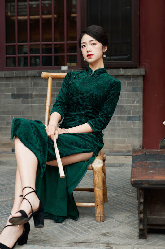 坐在中式庭院里身穿复古旗袍的亚洲女性