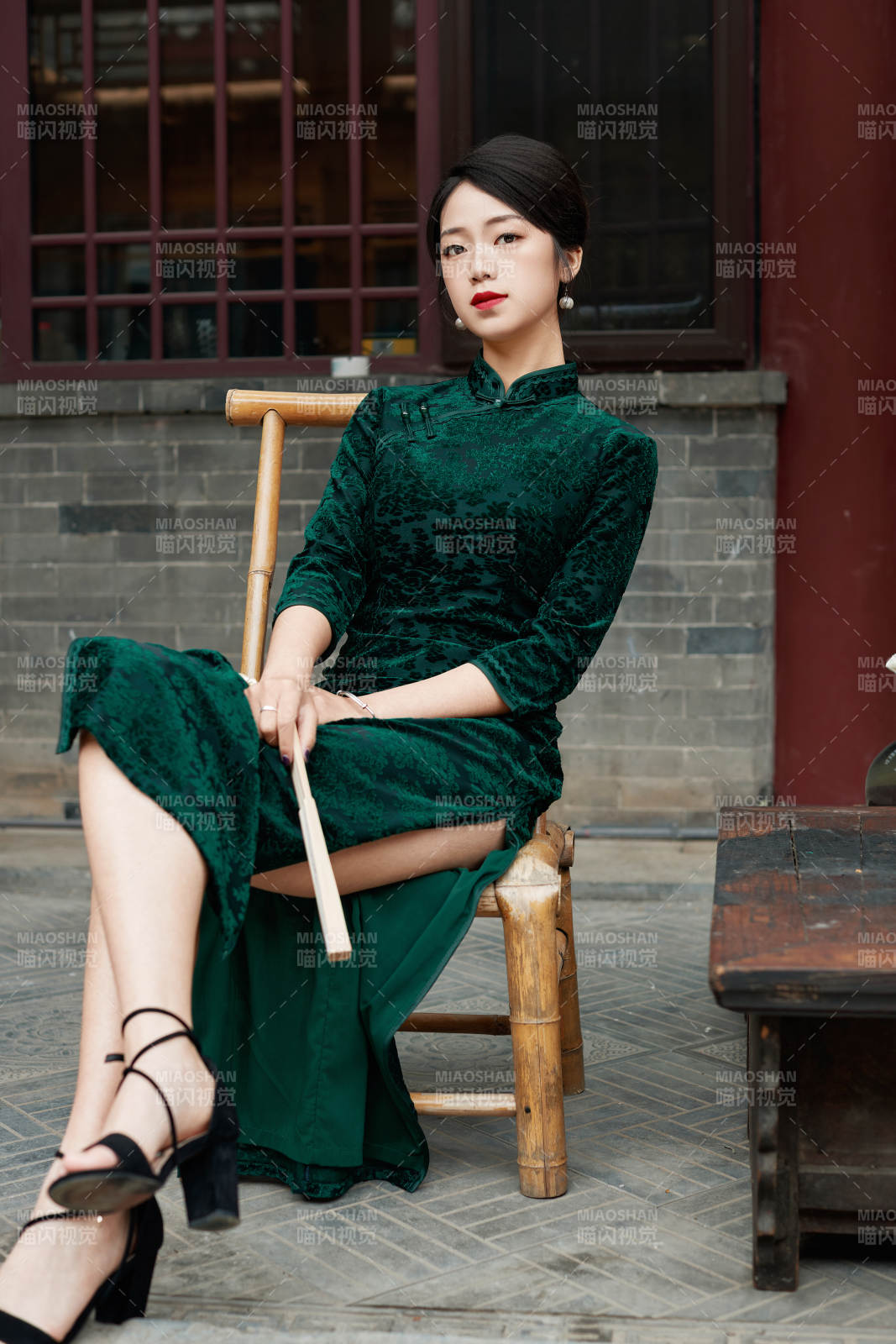 坐在中式庭院里身穿復古旗袍的亞洲女性