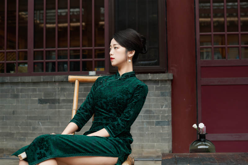 坐在中式庭院里身穿复古旗袍的亚洲女性