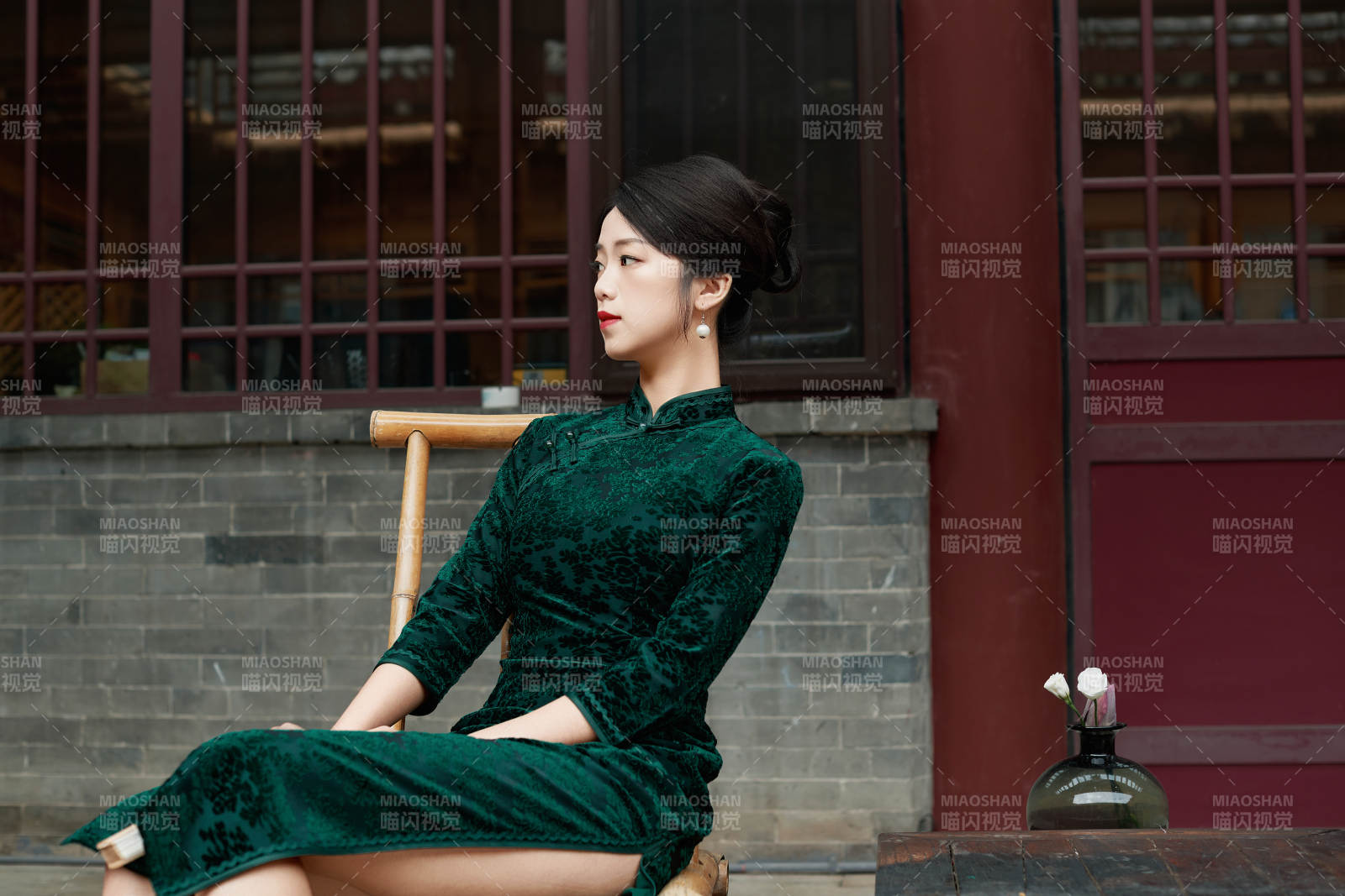 坐在中式庭院里身穿复古旗袍的亚洲女性