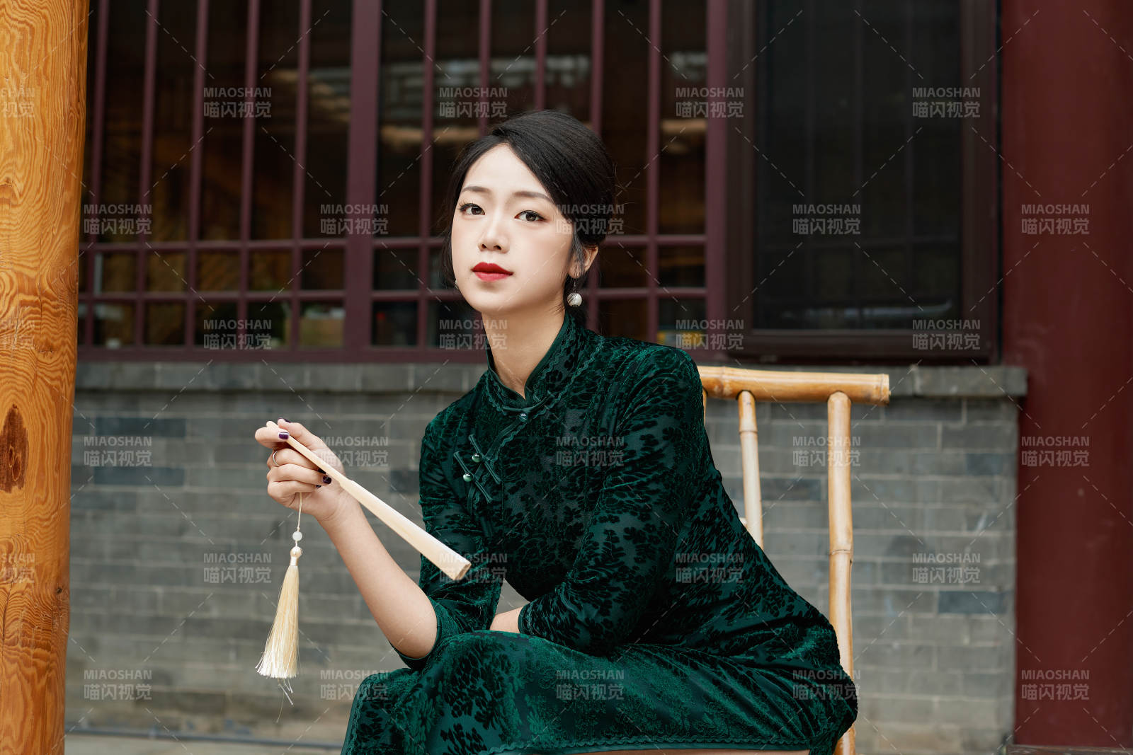 坐在中式庭院里身穿复古旗袍的亚洲女性