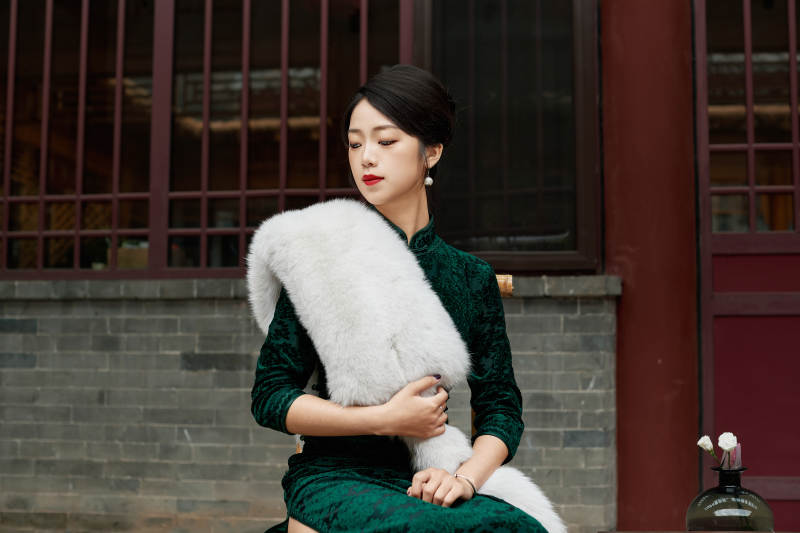 在中式庭院里身穿复古旗袍的亚洲女性