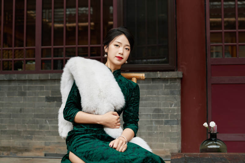 在中式庭院里身穿复古旗袍的亚洲女性