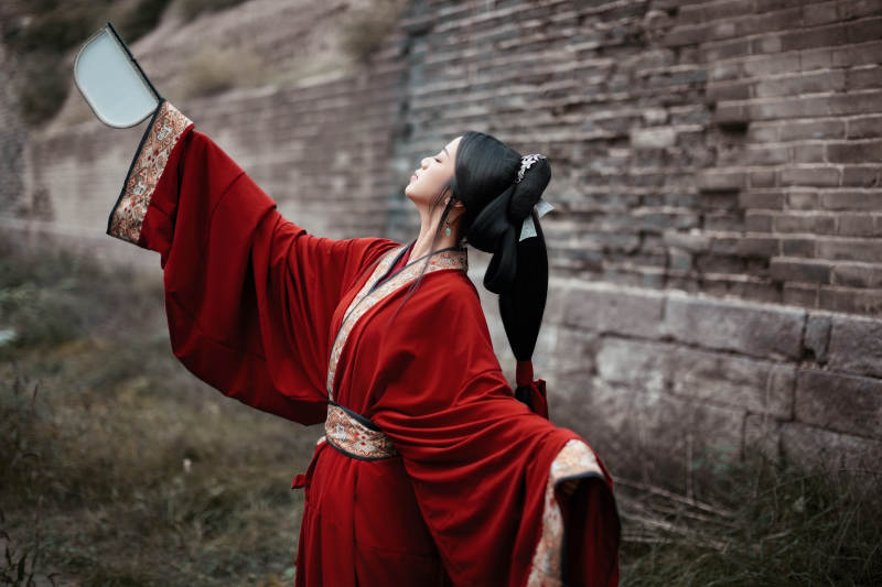身穿战国袍在古城游玩拍照的东方美女